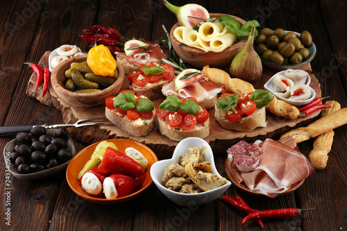 Italian antipasti wine snacks set. Cheese variety, Mediterranean olives, pickles, Prosciutto di Parma, tomatoes, artichokes