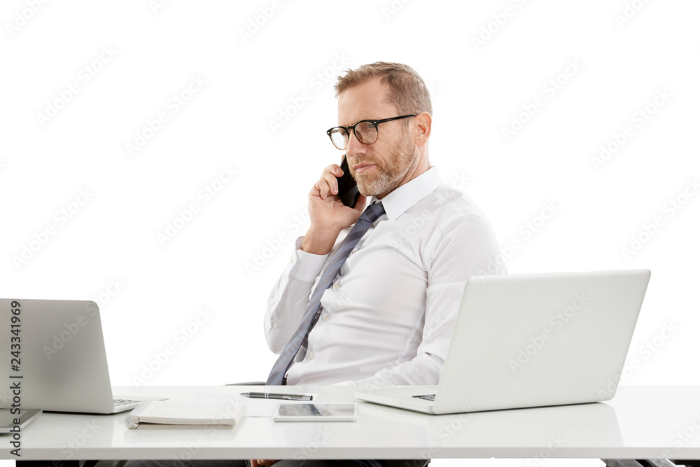 Businessman making call and working on laptop Businessman making call and working on laptop