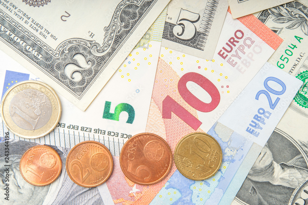 group of coins on background of various Euro and Dollar banknotes group of coins on background of various Euro and Dollar banknotes