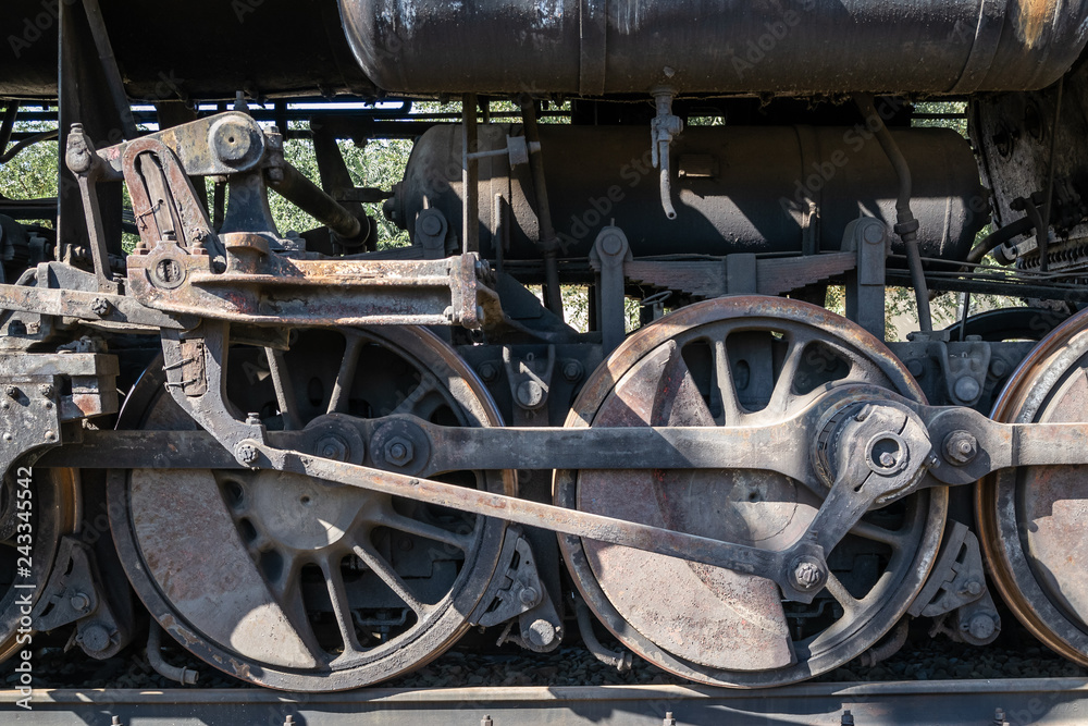 Old rusty wheels of the steam locomotive and the elements of the drive Old rusty wheels of the steam locomotive and the elements of the drive