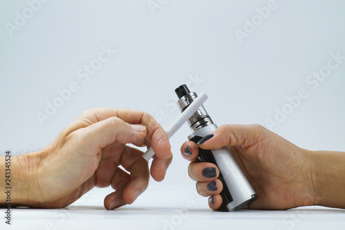 A man's hand with a cigarette and a woman's hand holding an e-cigarette. Addiction.