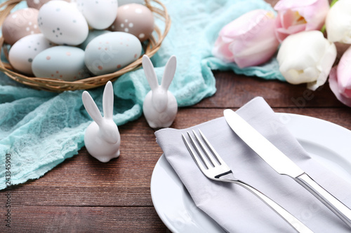 Obraz na płótnie Kitchen cutlery with easter eggs and ceramic rabbits on wooden table w salonie