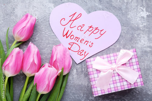 Bouquet of tulips with gift box and paper with inscription Happy Women Day