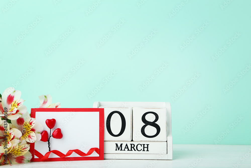 Greeting card with cube calendar and flowers on mint background Greeting card with cube calendar and flowers on mint background