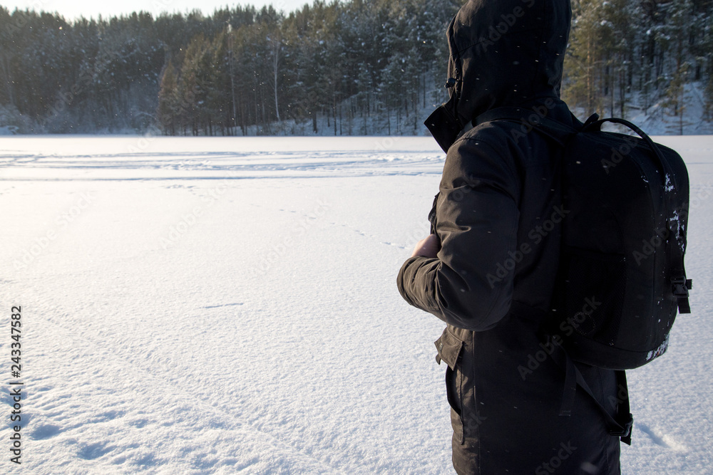 A man walking in the snow. Silhouette of a man walking on a snowy plain. Snowflakes falling