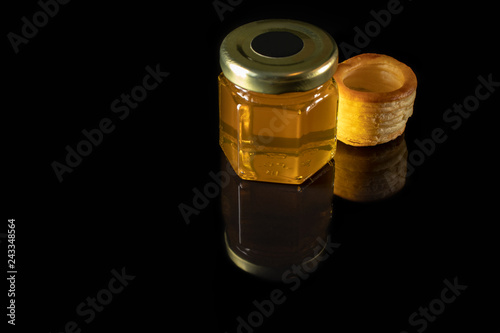 Wallpaper Mural A small jar of honey and dough tarts isolated on a dark background. Torontodigital.ca