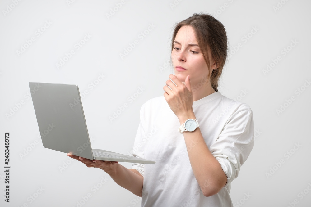 Smiling young european girl holding laptop computer Smiling young european girl holding laptop computer