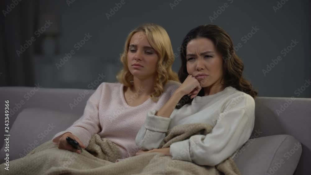 Two tired women watching long boring TV program at home and sleeping, night Two tired women watching long boring TV program at home and sleeping, night