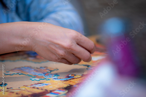 Adult and child solving a jigsaw puzzle on a table. 