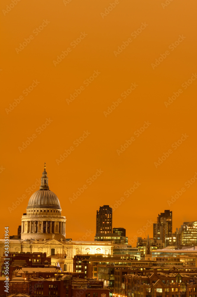 Saint Pauls Cathedral as seen from tate modern while an orange sunset acts a backdrop