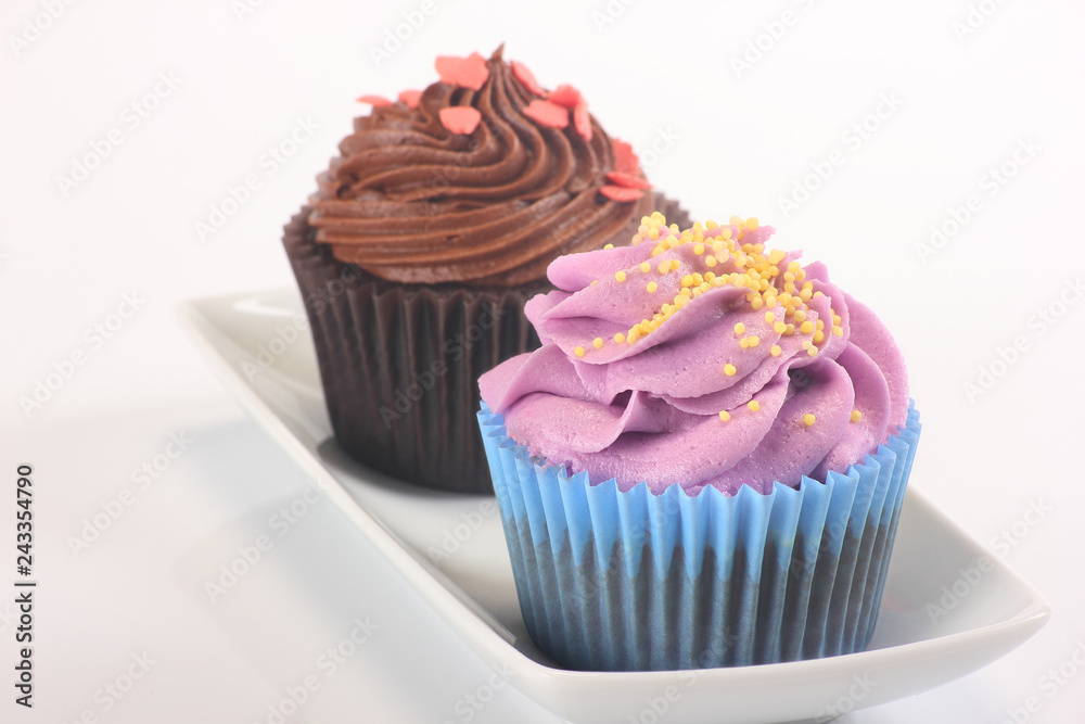 a pair of delicious cupcakes of different flavors on a rectangular plate