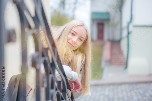 Blonde girl leans on stairs railing, urban portrait