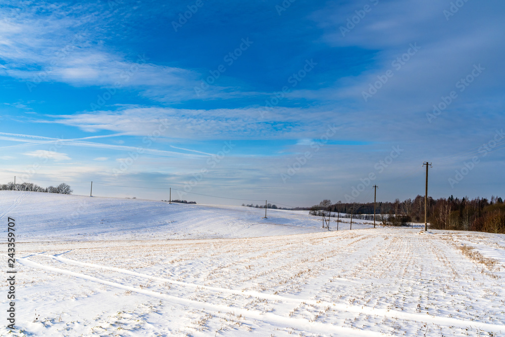 Empty Countryside Landscape in Sunny Winter Day with Snow Covering the Ground with Power Lines in Frame, Abstract Background with Deep Look