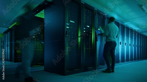 Time Lapse Footage of IT Employees Working in a Data Center Server Room. Technicians and Engineers Running Diagnostics and Maintenance, Inspecting Server Racks. photo