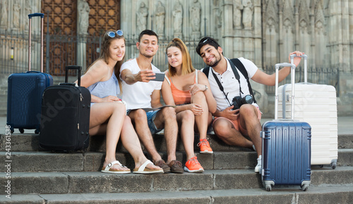 Fotografie Four travellers smiling and making selfie