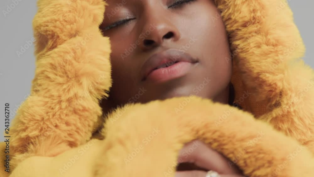 macro shoot of mixed race woman wear yellow hood with fur, and wrap up on it macro shoot of mixed race woman wear yellow hood with fur, and wrap up on it
