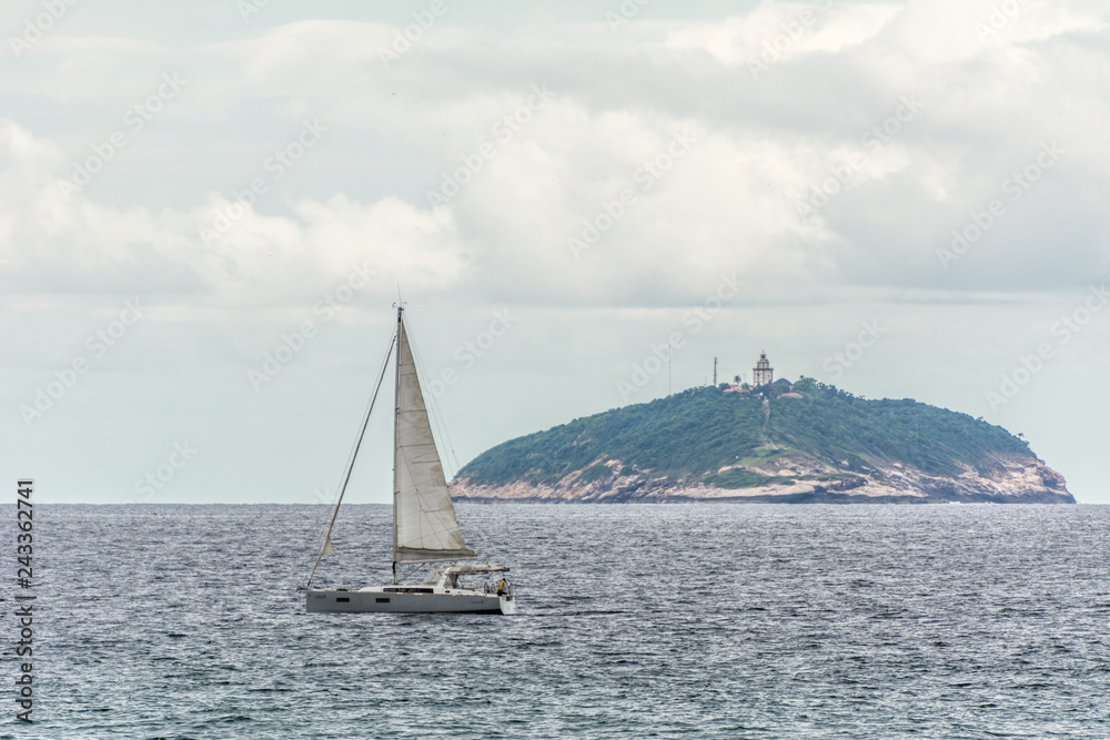 Sailing boat near an island, in Copacabana, Rio de Janeiro, Brazil.