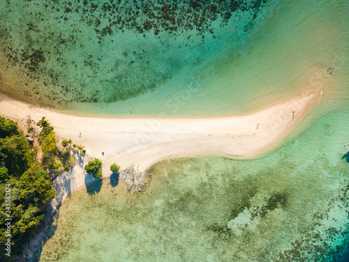Aerial top view of tropical beach on island Ditaytayan. Beautiful tropical island with white sandy beach, palm trees and green hills. Travel tropical concept. Palawan, Philippines
