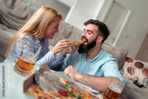 Happy couple eat pizza at home