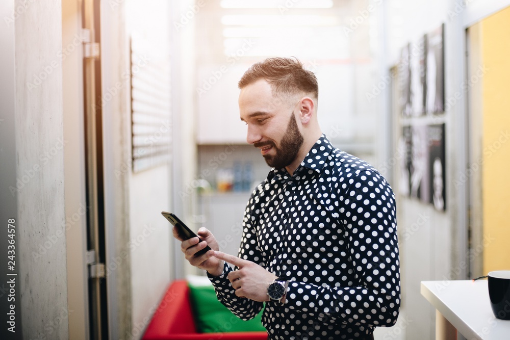 Caucasian businessman using smartphone in office.