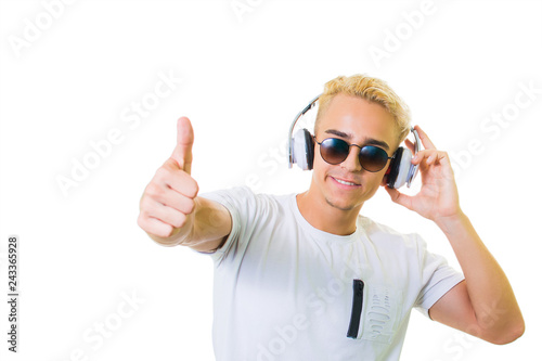 Handsome young man on an isolated background looking at camera. listens to music