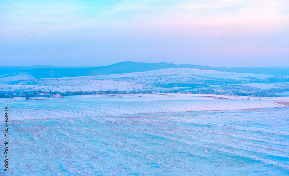 Sunset over hills covered with snow