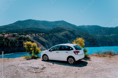 Vacation travel with car concept. Rental hired car in front of amazing bay with turquoise water. Discover Mediterranean Islands. Summer time holiday trip