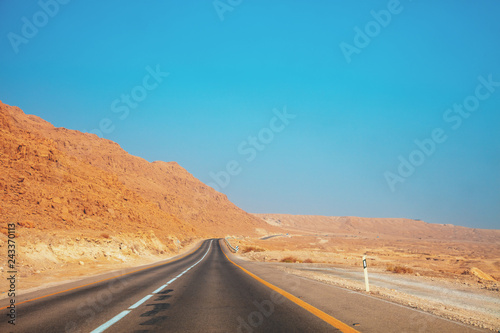 Driving a car in the desert in the early morning