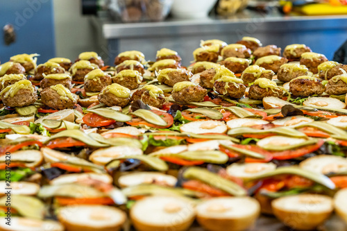 Closeup View of Sliced Bread Spread on the Table with Ingredients on them for Small Burgers - Kitchen Set, Concept of the Holiday Evening Dinner Table