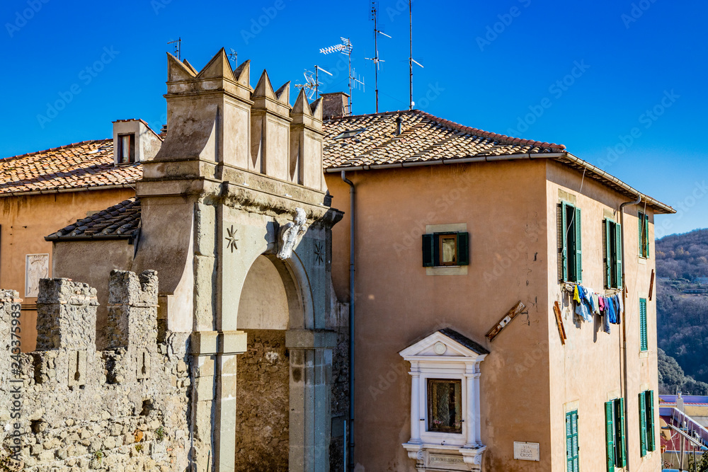 Medieval door of Ariccia. Stone arch, coat of arms, entrance, niche. Castelli Romani, Lazio, Italy.