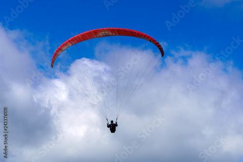 Flying on a parachute in the blue sky