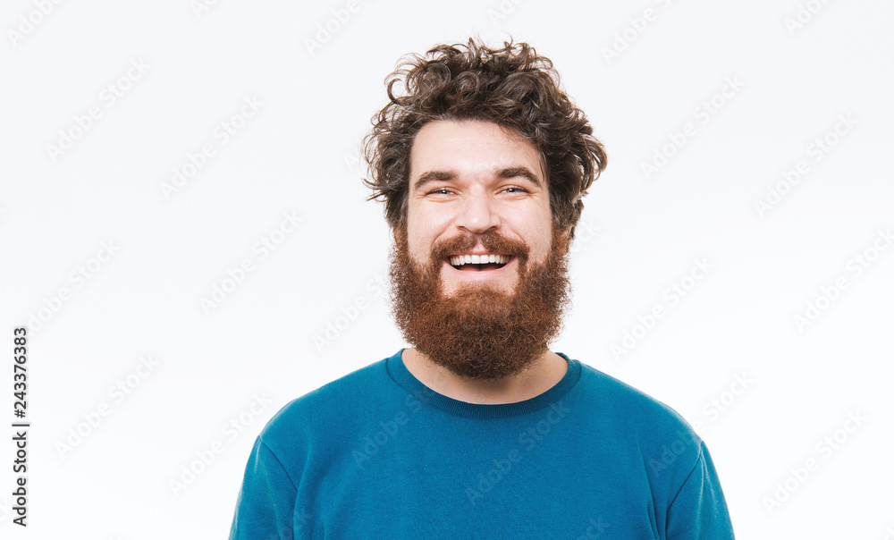 Fototapeta premium Portrait of happy bearded man in blue pullover smiling at camera