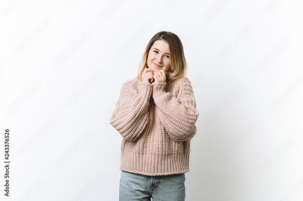 Portrait of slender beautiful woman in love, holding clasped hands over chest, looking tender pose Portrait of slender beautiful woman in love, holding clasped hands over chest, looking tender pose