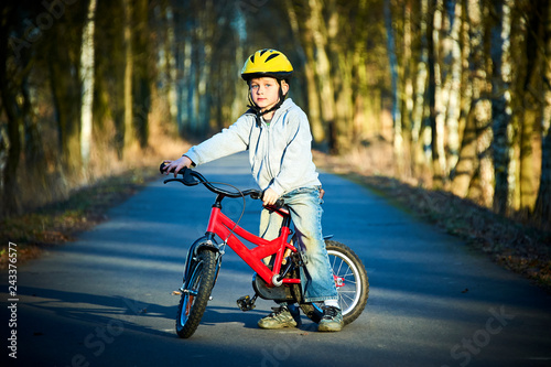 Boy riding his bike on a spring country track. Road concept for safety and child development