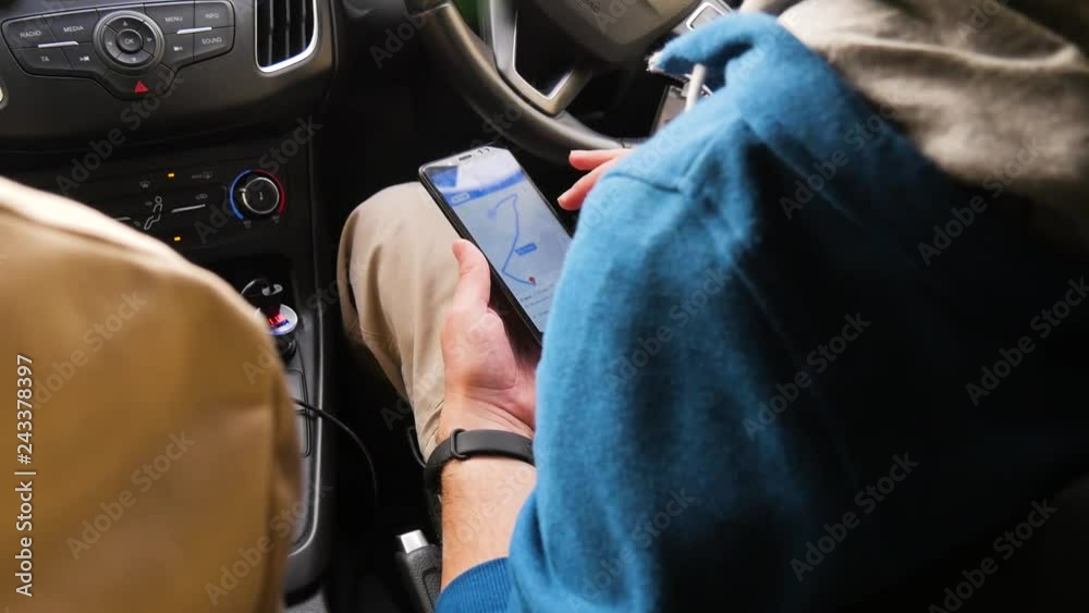 Tourists choose the direction on the map in the phone. The man is looking for a destination.