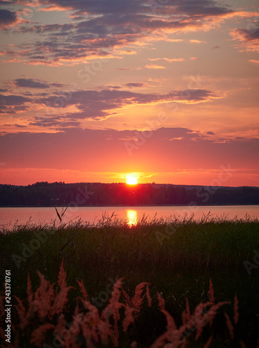 Idyllic sunset sky with the sun and colorful clouds photo