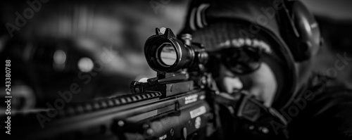 man looks through scope on rifle