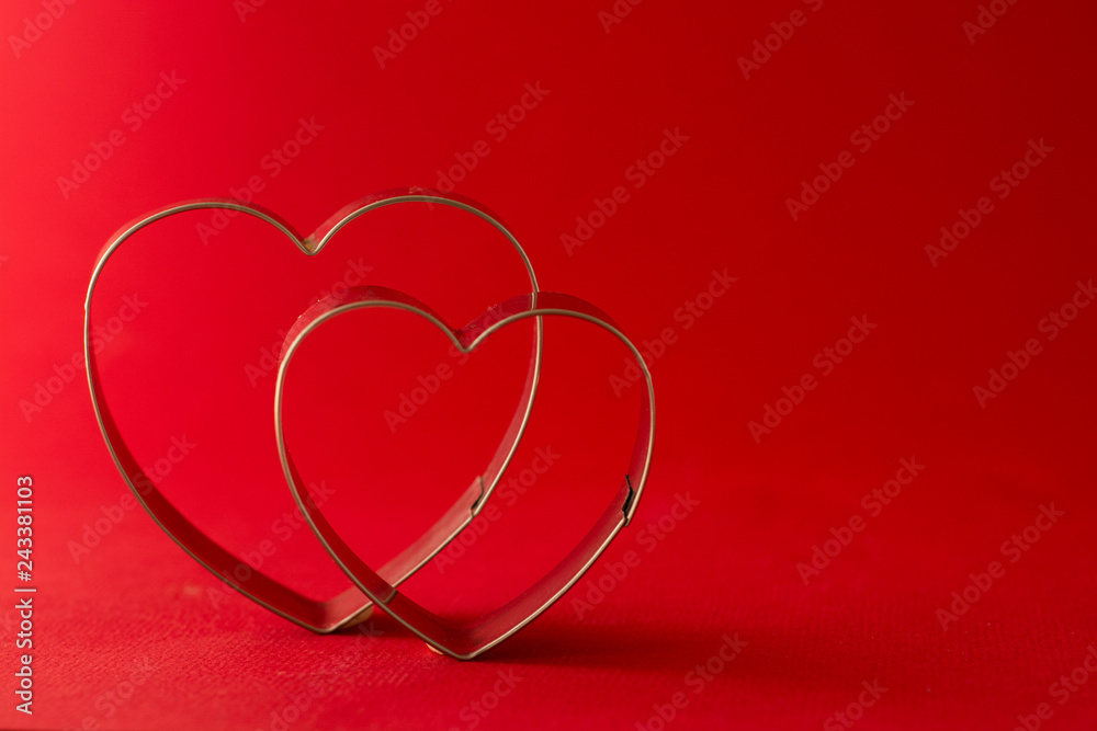 Happy Valentine's Day Greeting card. Two red heart shaped cookie cutters on beautiful red background. Happy Valentine's Day Greeting card. Two red heart shaped cookie cutters on beautiful red background.