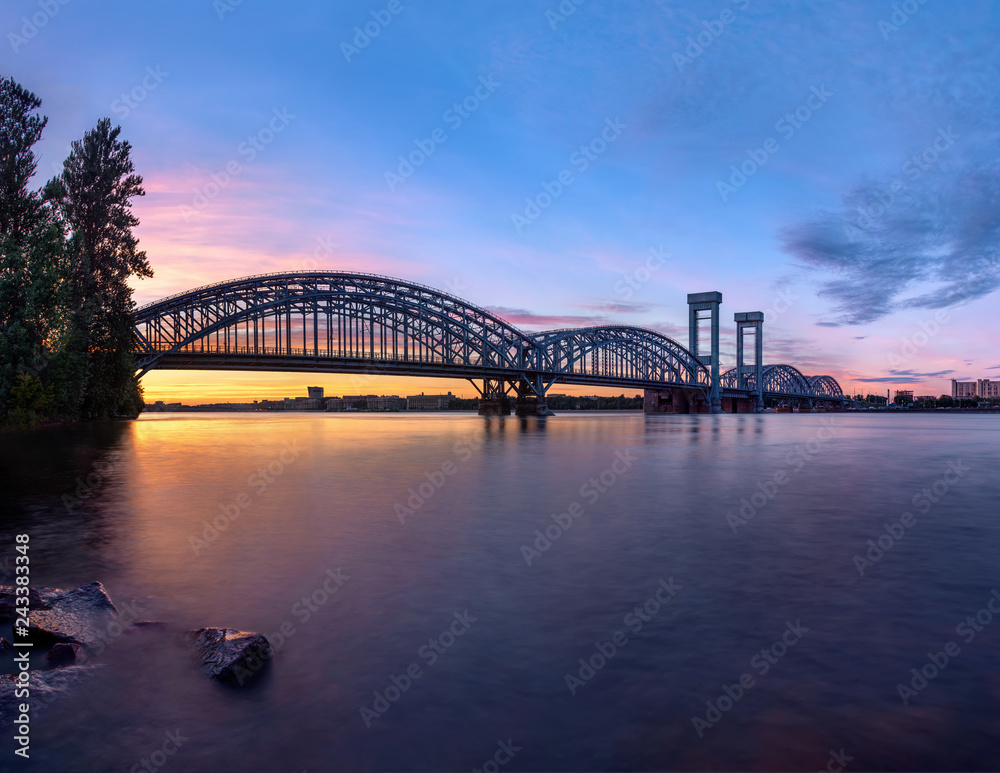 railroad bridge at beauty sunset with flat water