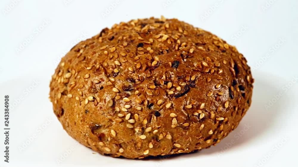 Burger bun with sunflower seeds rotating on white background Burger bun with sunflower seeds rotating on white background