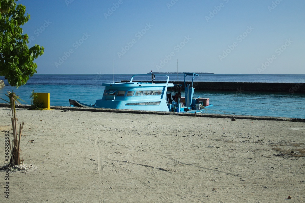 Isolated blue boat in the harbor (Ari Atoll, Maldives)