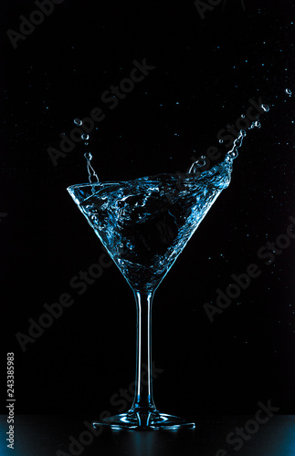 Cocktail martini glass splash on black background