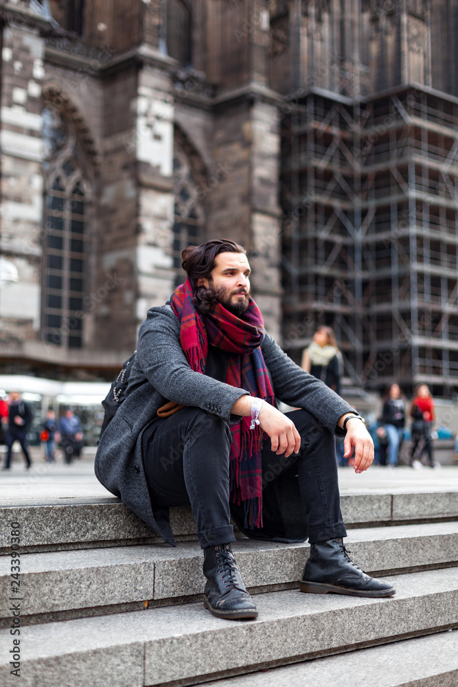 Stylish young man with beard sitting on the stairs Stylish young man with beard sitting on the stairs