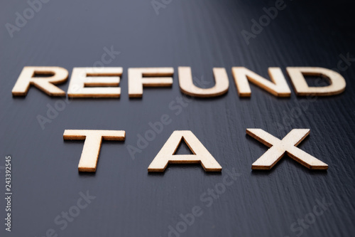 The inscription is arranged from letters cut out of wood on the table. The word – refound tax. photo