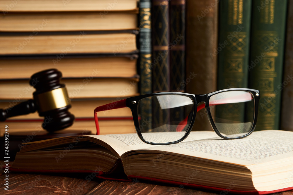 Judge gavel and legal book collection with eyeglasses on wooden Judge gavel and legal book collection with eyeglasses on wooden