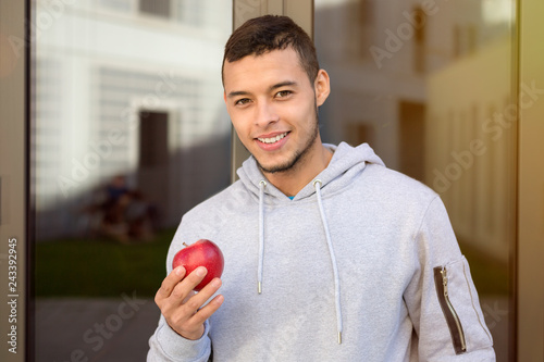 Junger Mann Latino isst essen Apfel Frucht Sport Training Jogger Fitness