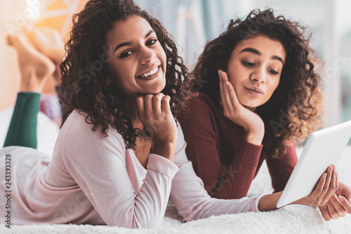 Curly sisters having video chat with their parents