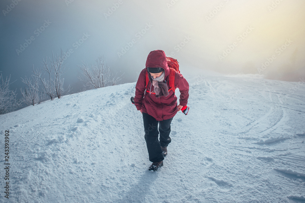 Woman hike in winter snowy misty nature. Adventure in mountains