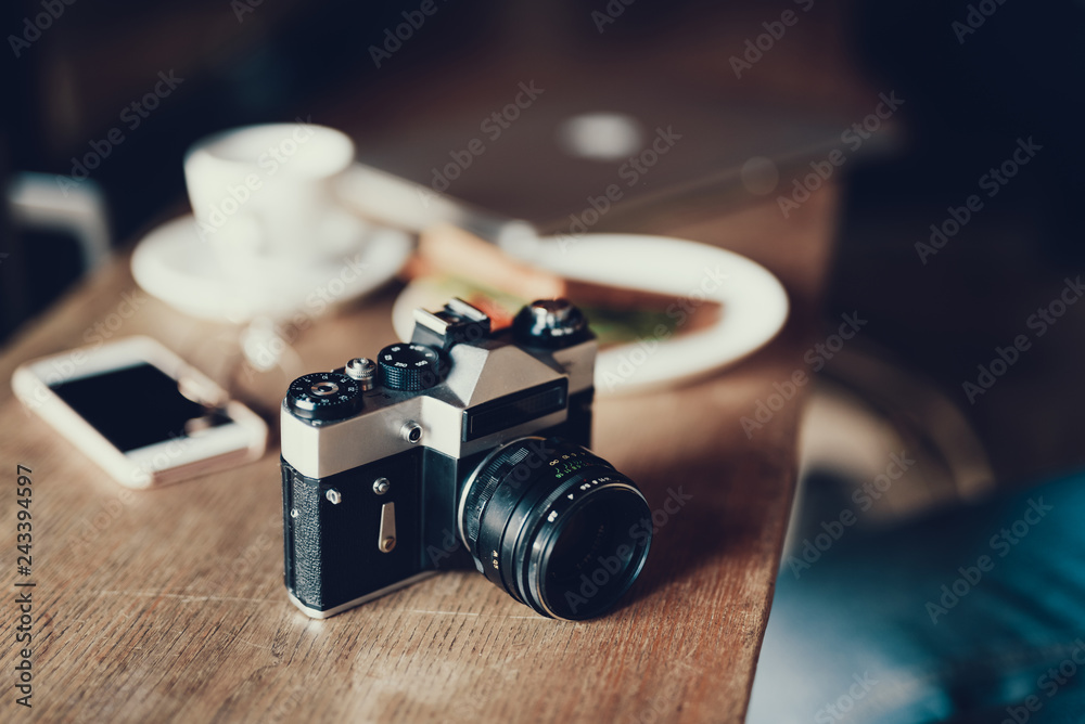 Old fashioned photo camera lying on wooden table