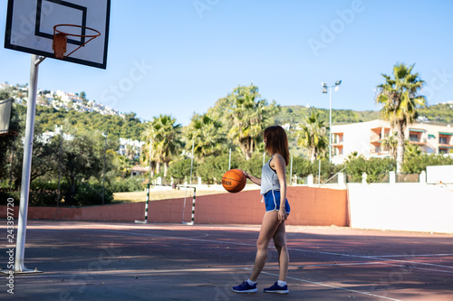 Young woman enjoys on the basketball court with her ball © lymdigital